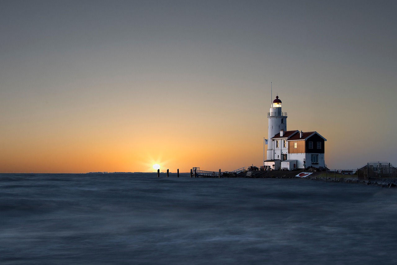 Lighthouse on beach at sunset